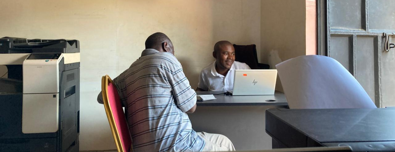 Mohaa helping a client at Mohaa Computers, Diani